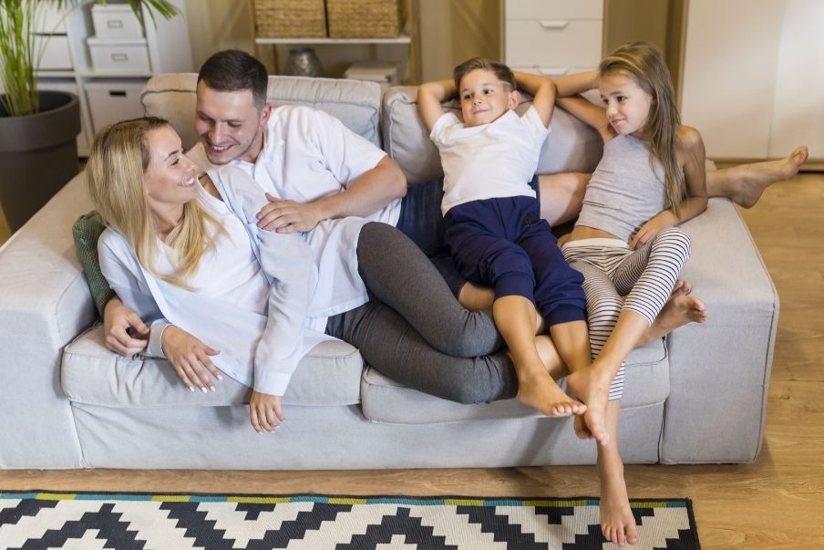 Família confortável no sofá limpo